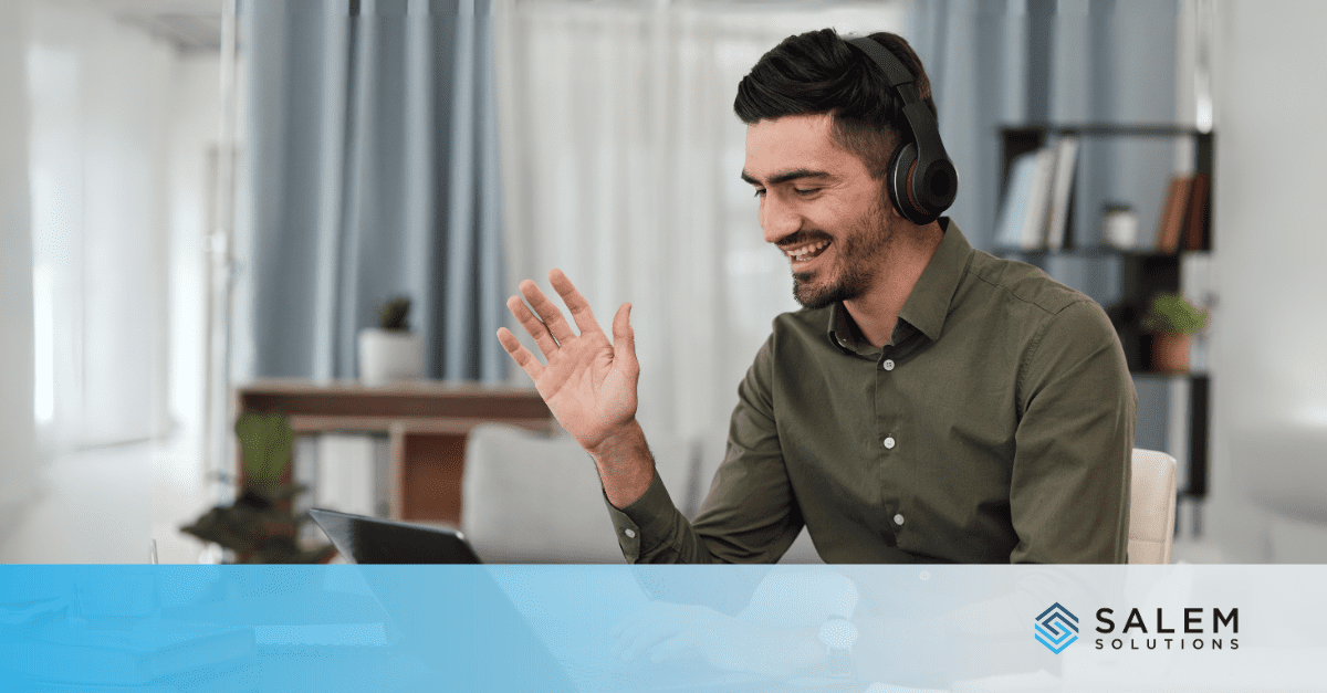 Man in headphones chats on laptop, working a remote call center job in a bright office.