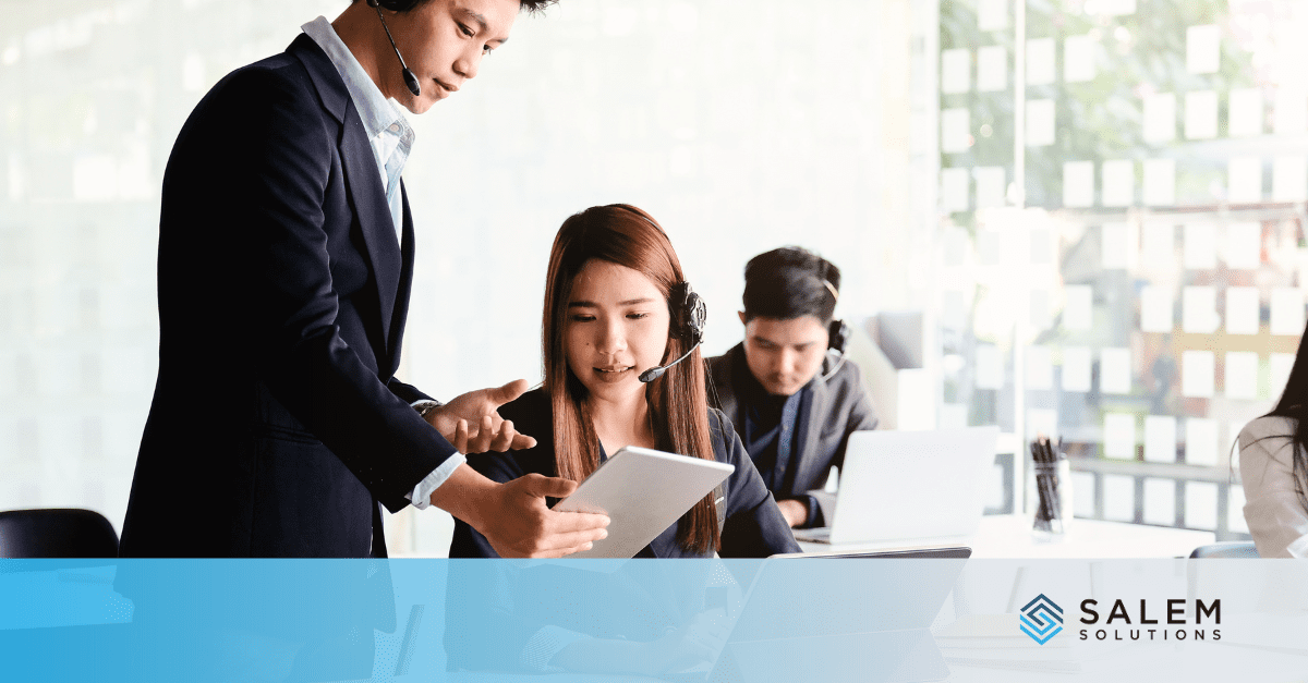 A man and woman collaborate in an office, discussing strategies for optimizing customer service team performance.