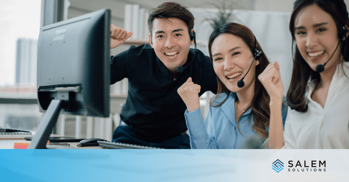 A group of people standing around a computer monitor.