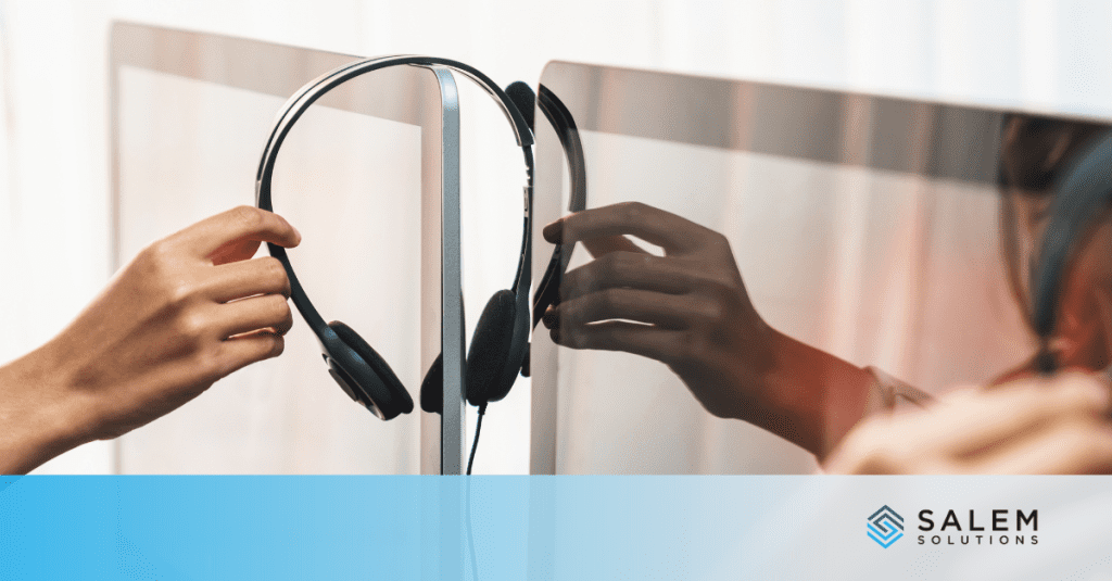 A hand is holding a pair of headphones.