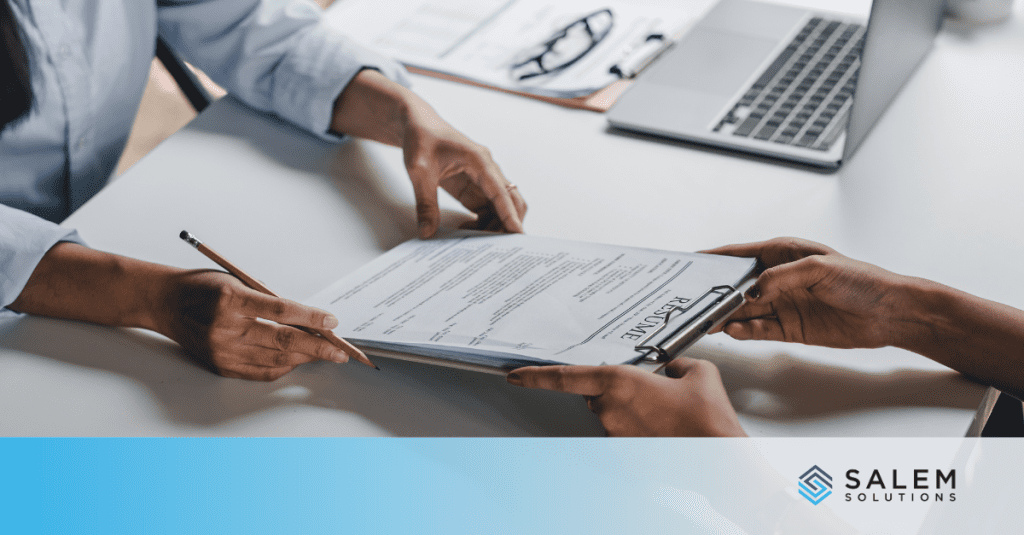 Two people at a desk poring over a document, discussing call center forecasting.
