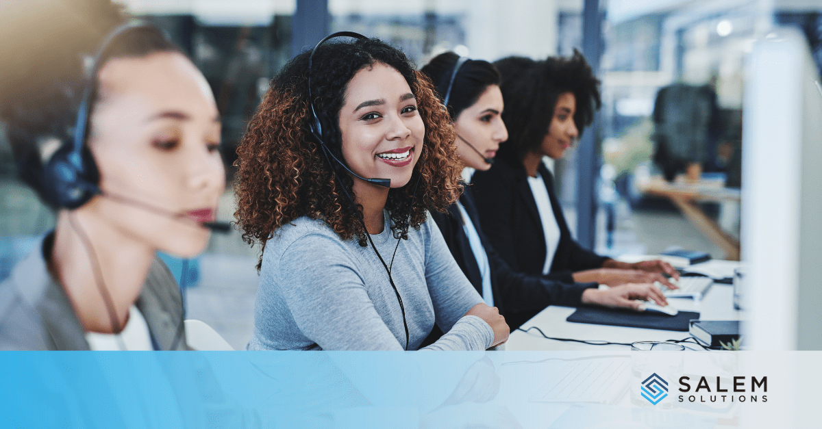 Smiling call center agent at workstation representing successful seasonal hire to full-time employee career advancement.